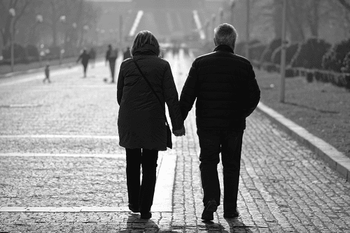 Medicare aged couple walking hand in hand